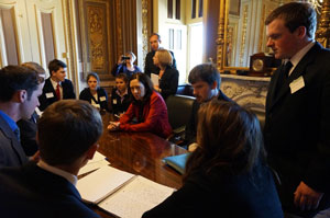 Teenagers gathered around a table with Senator Maria Cantwell.