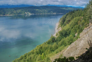 Cliff and bay, mountains beyond.