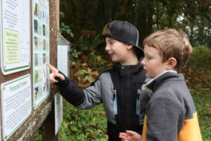 Students examine the Land Trust's interpretive sign at Valley View Forest.