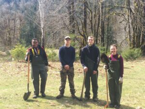 4 teenagers in a sunny clearing with shovels