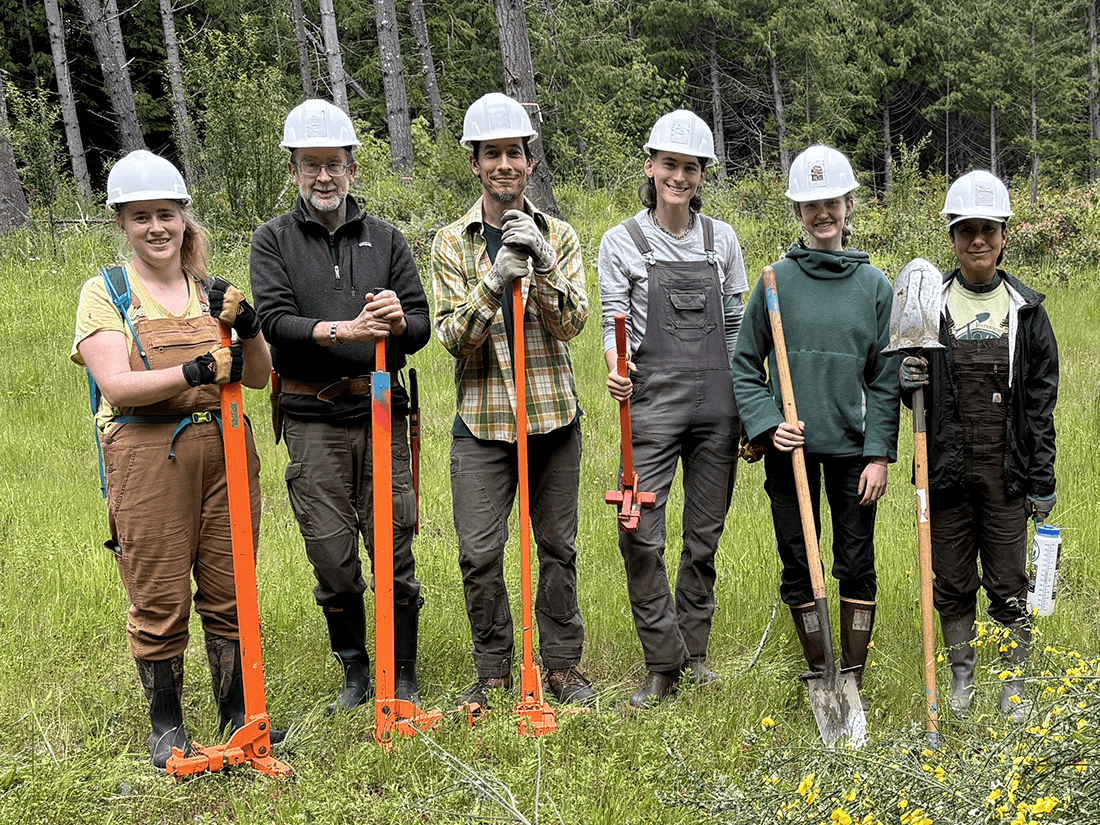 IMG_0712-Americorps-Staff-sm Photo of six people with tools standing in a clearing with trees in the background.