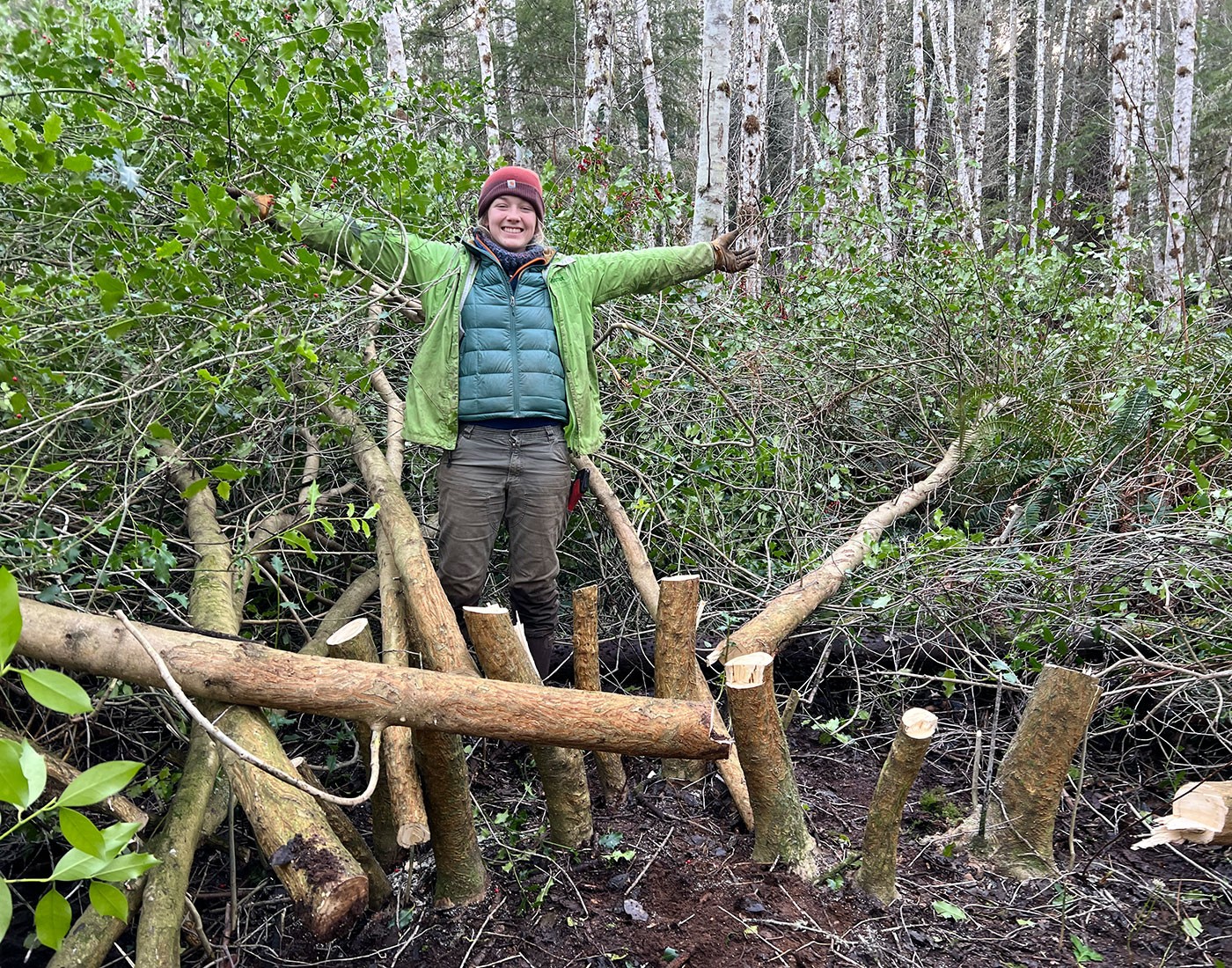 Young woman in forest posing with holly tree stumps and foliage