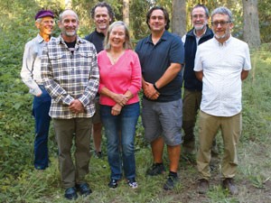 Group photo of seven people in forest