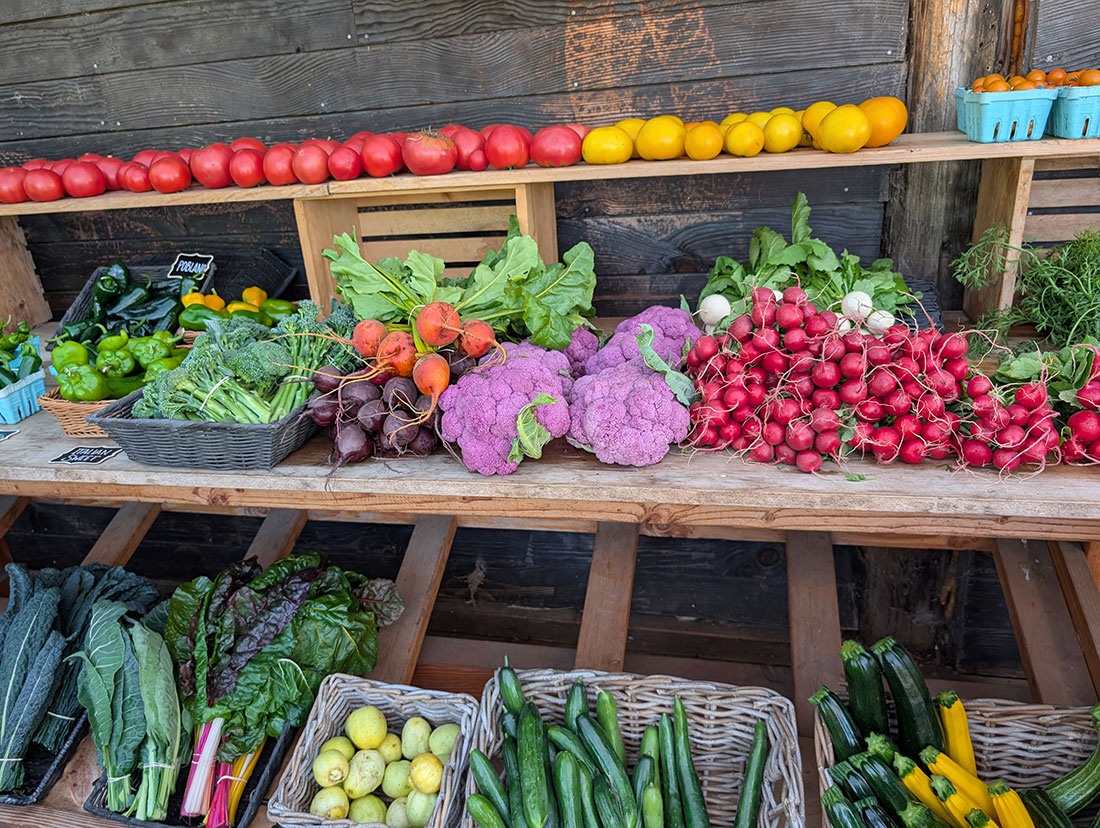 newPXL_20250913_220822102 Colorful vegetables arranged on table and shelves