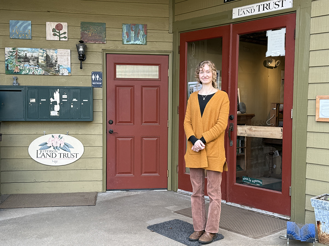 Photo of a woman standing in front of an office door.